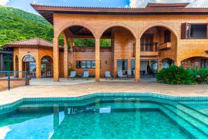 a house with a swimming pool in front of a building at Mansão VOAR in Florianópolis