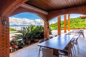 an outdoor patio with a wooden table and chairs at Mansão VOAR in Florianópolis