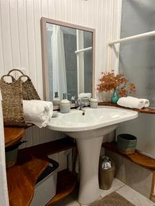 a bathroom with a white sink and a mirror at Fare Miti Ora Moorea - Bungalow mitoyen in Hauru +17 photos