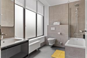 a bathroom with a tub and a toilet and a window at Uni88 ApartHotel in Bucharest