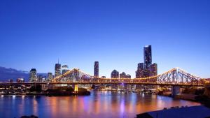 a bridge over a river with a city at night at Cozy Studio in Adina Brisbane CBD Anzac Square in Brisbane
