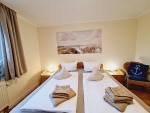 Una habitación con dos camas con toallas. en Fewo Jara, en Kägsdorf