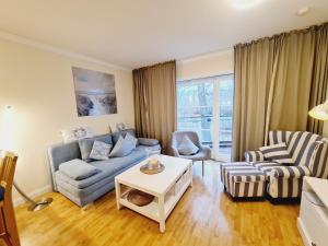 Una sala de estar con un sofá y sillas y una mesa. en Fewo Jara, en Kägsdorf