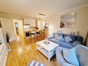 Una sala de estar con un sofá azul y una mesa. en Fewo Jara, en Kägsdorf