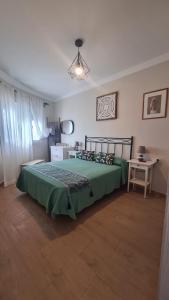 a bedroom with a green bed and a table at Apartamento Boquerón I in Sitio de Calahonda