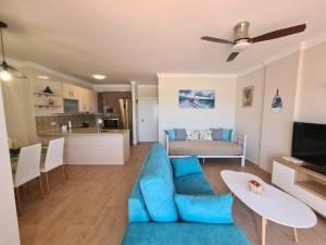a living room with a blue couch and a kitchen at Apartamento Boquerón I in Sitio de Calahonda