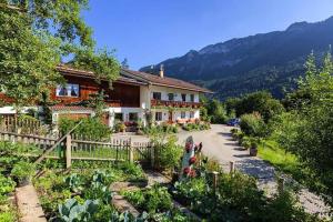 a house with a garden in front of it at Pension Scheuerbichl in Bischofswiesen +32 photos