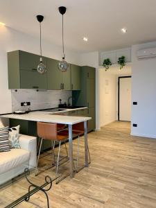 a kitchen with green cabinets and a table and chairs at Lettera Luxury Apartment in Formia +11 photos