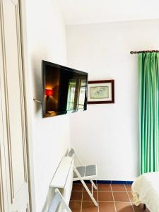 a room with a television on a wall with a chair at Puente del Rey, El Rocio Deluxe in El Rocío