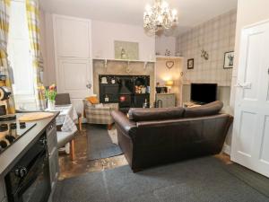 a living room with a couch and a fireplace at West Wing Cottage in Sandhoe
