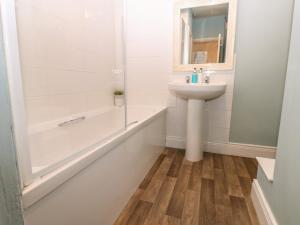 a bathroom with a sink and a bath tub and a mirror at West Wing Cottage in Sandhoe +17 photos