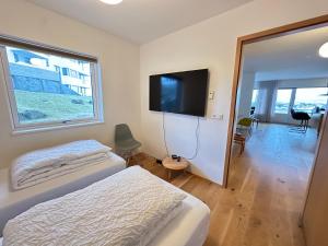 a bedroom with a bed and a flat screen tv at Apartment in Austurkór- Birta Rentals in Reykjavík