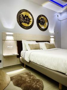 a bedroom with a bed with three plates on the wall at Residhomes Apparthôtel Saint-louis 202 in Saint-Louis
