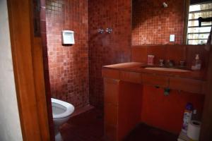 een badkamer met een toilet, een wastafel en een spiegel bij Iemanyá in Villa Gesell +16 foto's
