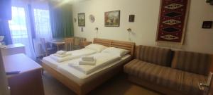 una camera da letto con un letto e un divano di Casa Alpina Relax - Pool&Sauna - by Hermann Weiss a Saalbach Hinterglemm Altre 121 foto