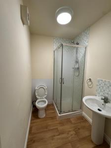 a bathroom with a shower and a toilet and a sink at Barnsley Guesthouse in Barnsley