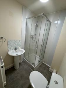 a bathroom with a shower and a toilet and a sink at Barnsley Guesthouse in Barnsley