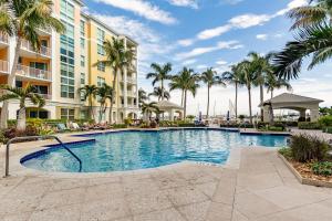 a swimming pool in front of a building with palm trees at Spacious 3BR 3BA with King Bed & Amazing Pools near Intercoastal, Lantana Beach, FL in Lantana