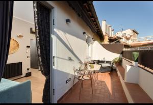 eine Terrasse mit Tisch und Stühlen auf einem Balkon in der Unterkunft Florence Holiday Apartment Ponte Vecchio Glow Suite Jacuzzi in Florenz