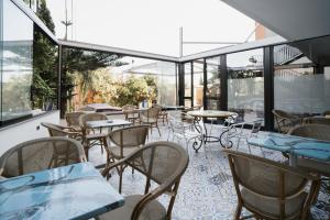 an empty restaurant with tables and chairs and windows at Hotel Caribe in Casalnuovo di Napoli