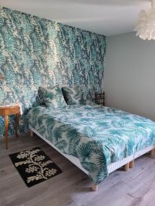 a couch in a room with a green and white wallpaper at Appartement T3 calme avec belle vue in Poisy