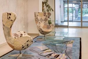 two chairs and a glass table in a room at Best Western Hotel Vista in Ostrava