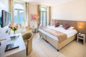 a hotel room with a bed and a desk at Best Western Hotel Bellevue au Lac in Lugano +22 photos