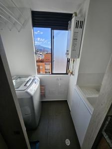 uma pequena casa de banho com uma máquina de lavar roupa e uma janela em Moderno Apto 1HAB para 2 hasta 4 personas con Vista Panorámica en Usaquén, WiFi Rápido y Cocina Equipada em Bogotá