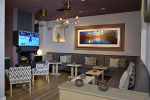 a living room with a couch and a tv at Best Western Hotel Der Föhrenhof in Hannover