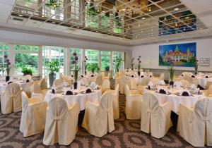 a banquet hall with white tables and chairs at Best Western Hotel Der Föhrenhof in Hannover