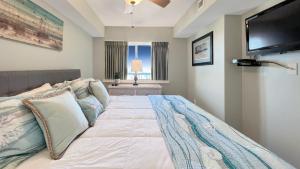 a bedroom with a large bed with a flat screen tv at Malibu Pointe - 602 in Fall River +30 photos