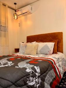 a bedroom with a bed with a blanket on it at Salam appartement climatisé hiver et été in Azrou +16 photos