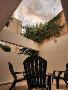 two chairs sitting on a patio next to a wall at Departamento con cochera cerca del centro en Mendoza in Mendoza +9 photos