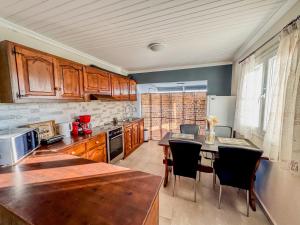 a kitchen with wooden cabinets and a table with chairs at Beachlife: The Bungalow in Kos