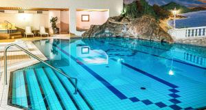 a large swimming pool with a mountain mural on the wall at Best Western Victor's Residenz-Hotel Rodenhof in Saarbrücken