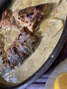 a pan of food with two pieces of meat at Board apartment in Irbid +21 photos