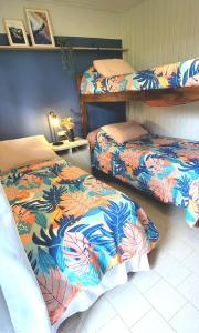 a bedroom with two beds with colorful blankets at Lago Argentino Hostel in El Calafate +60 photos