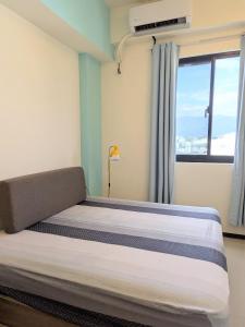 a bedroom with a large bed with a window at 海雲間 in Taitung City