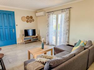 a living room with a couch and a tv at Beachlife: The Bungalow in Kos