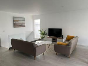 a living room with two couches and a tv at Queen Villa - Santa Barbara - Lourinha in Santa Barbara