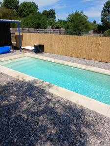 a swimming pool with blue water in a backyard at Utopía Hogar in Balneario Argentino