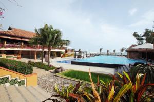 a resort with a swimming pool and a building at Poshanu Boutique Resort in Mui Ne