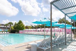 チャールストンにあるThe Esben comfy 1 bedroom close to everythingのスイミングプール(椅子、青いパラソル付)