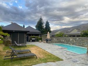 a backyard with a swimming pool and a house at Studio 18 Cardrona in Cardrona