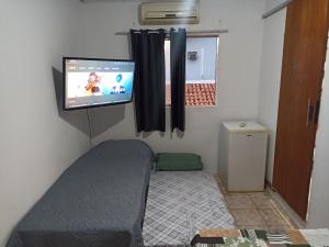 a small room with a bed and a tv on the wall at Refúgio de Piratininga 203 in Niterói