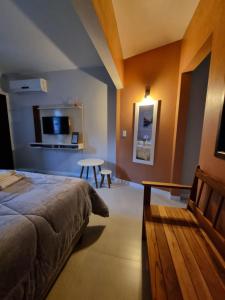 a bedroom with a bed and a table in a room at Frieden Haus Hospedagem in Pomerode