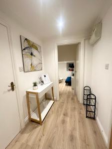 a hallway with a table and a desk in a room at Cosy 1 bedroom flat in London in London