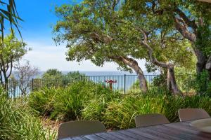 una mesa con sillas y vistas al océano en Waves #1 by Discover Stradbroke, en Point Lookout
