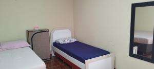 a small room with a small bed and a mirror at Espaço Moura in Chapada dos Guimarães
