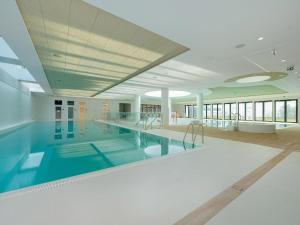 a large swimming pool in a large building with a pool at Apartment in Pobierowo with Sea View in Pobierowo